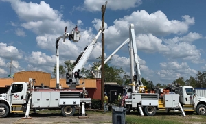 valiant bucket trucks repairing damaged powerlines in town